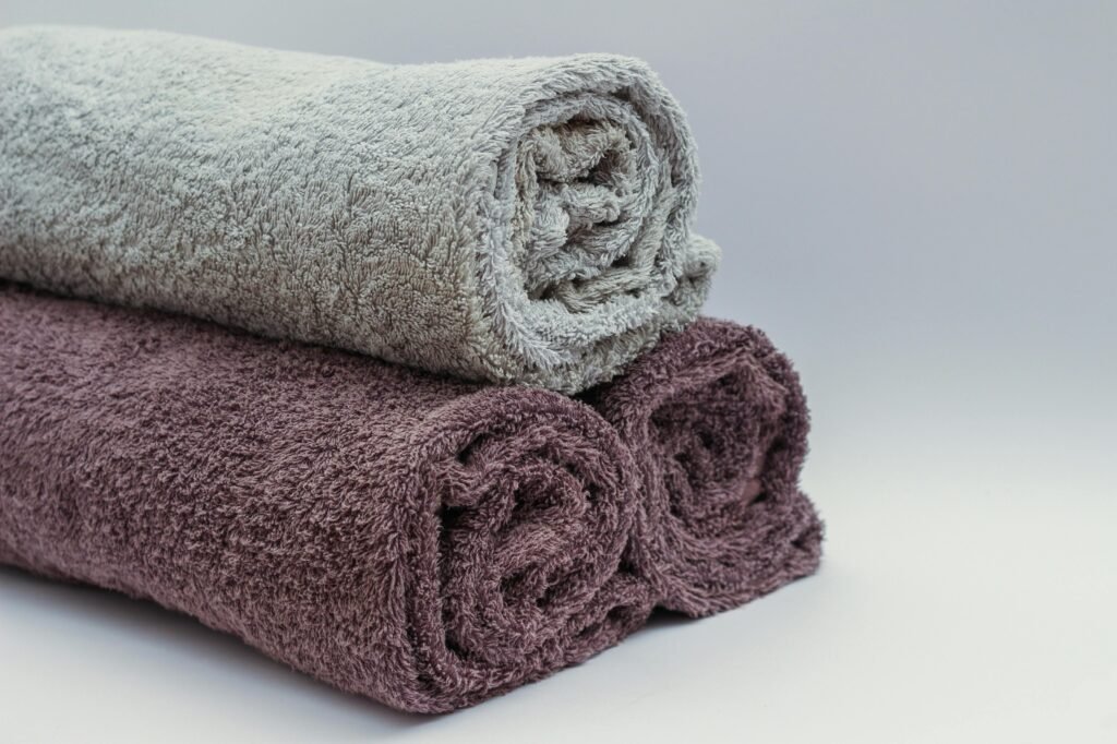 Close-up of rolled bathroom towels in neutral tones, ideal for interior design or spa themes.